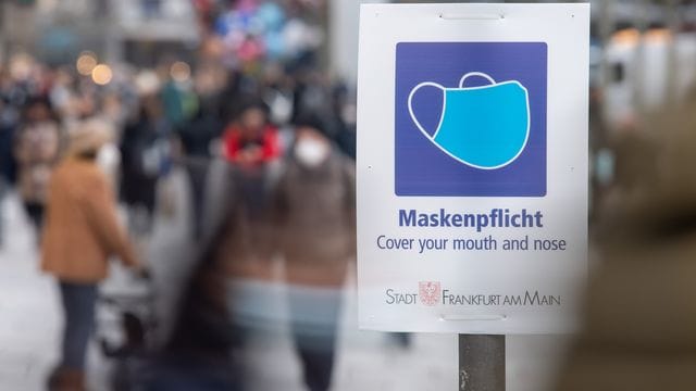 Ein Schild weist auf der Einkaufsstraße Zeil auf die Maskenpflicht hin. Ein Schild weist auf der Einkaufsstraße Zeil auf die Maskenpflicht hin.