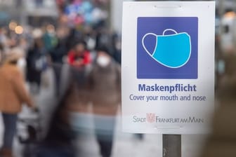 Ein Schild weist auf der Einkaufsstraße Zeil auf die Maskenpflicht hin.