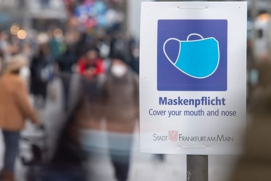 Ein Schild weist auf der Einkaufsstraße Zeil auf die Maskenpflicht hin.