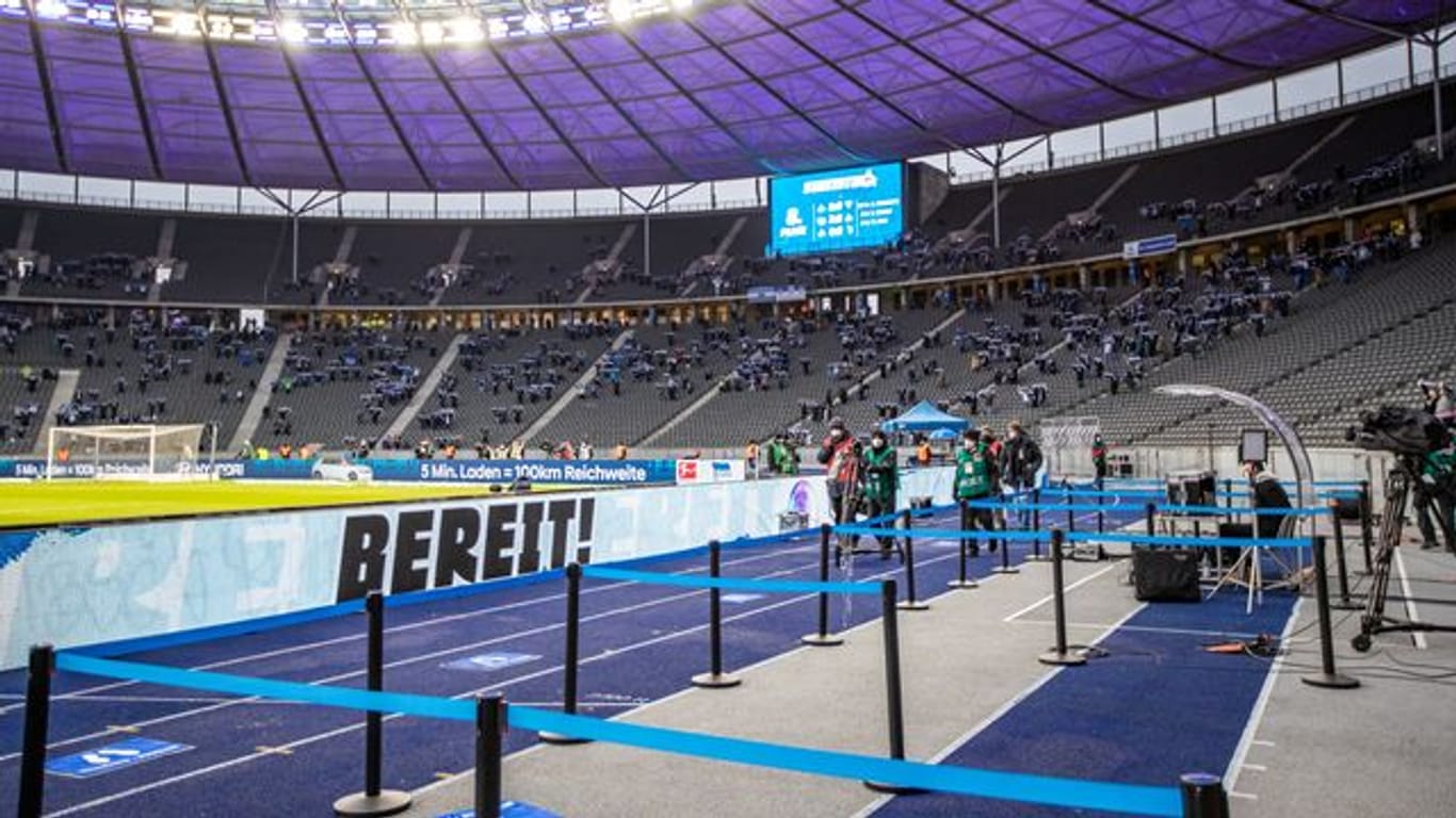 Vereinzelt stehen Fans auf den Tribünen im Berliner Olympiastadion.