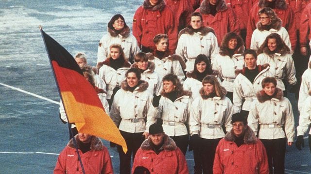 Hinter ihrem Fahnenträger zieht die deutsche Mannschaft 1992 in das Stadion von Albertville ein.