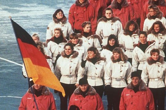 Hinter ihrem Fahnenträger zieht die deutsche Mannschaft 1992 in das Stadion von Albertville ein.