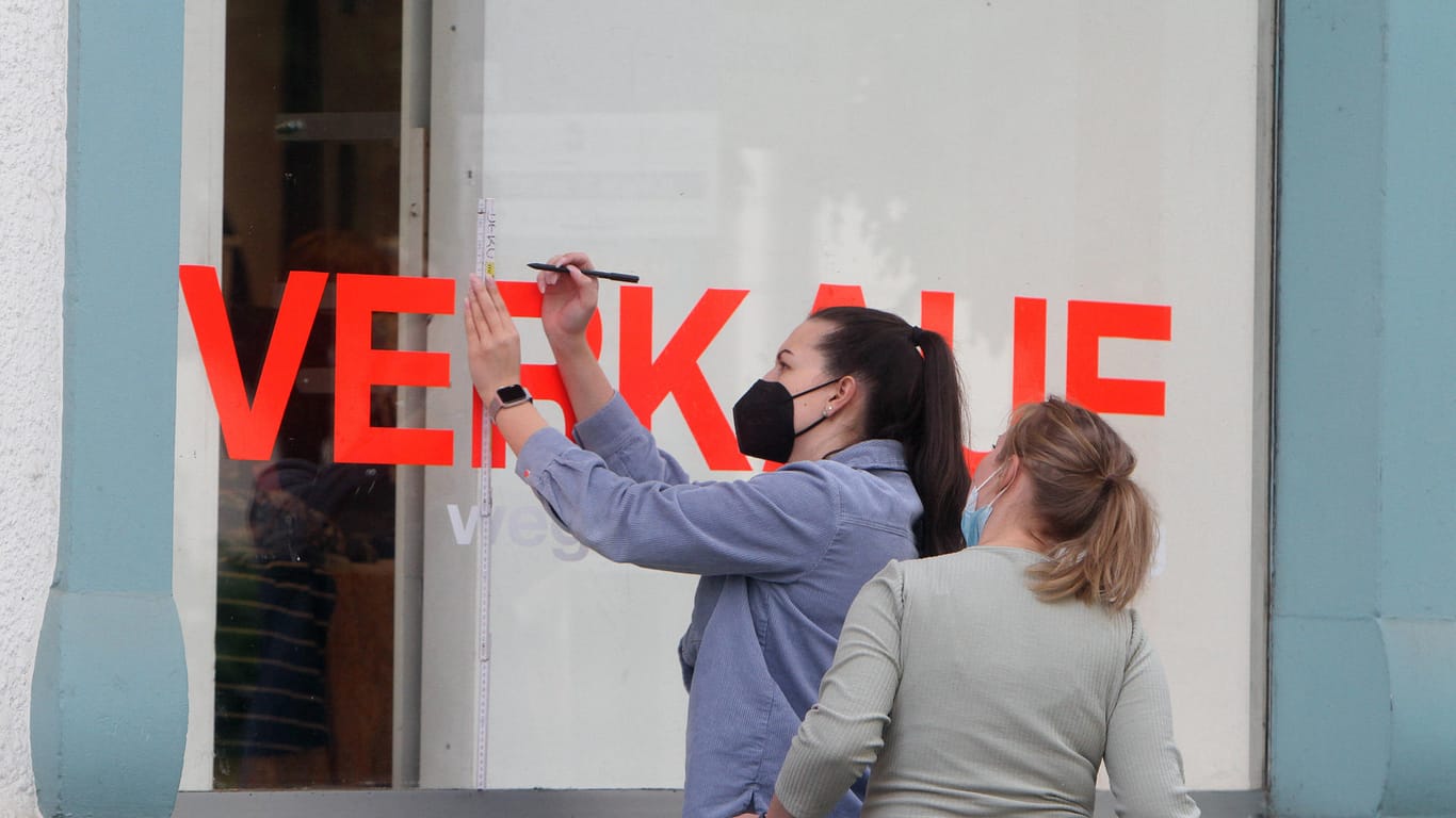 Mitarbeiterinnen überkleben das Schaufenster eines Modegeschäfts mit dem Schriftzug Verkauf (Symbolbild): Die aktuelle Corona-Verordnung sieht 2G im Einzelhandel vor