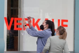 Mitarbeiterinnen überkleben das Schaufenster eines Modegeschäfts mit dem Schriftzug Verkauf (Symbolbild): Die aktuelle Corona-Verordnung sieht 2G im Einzelhandel vor