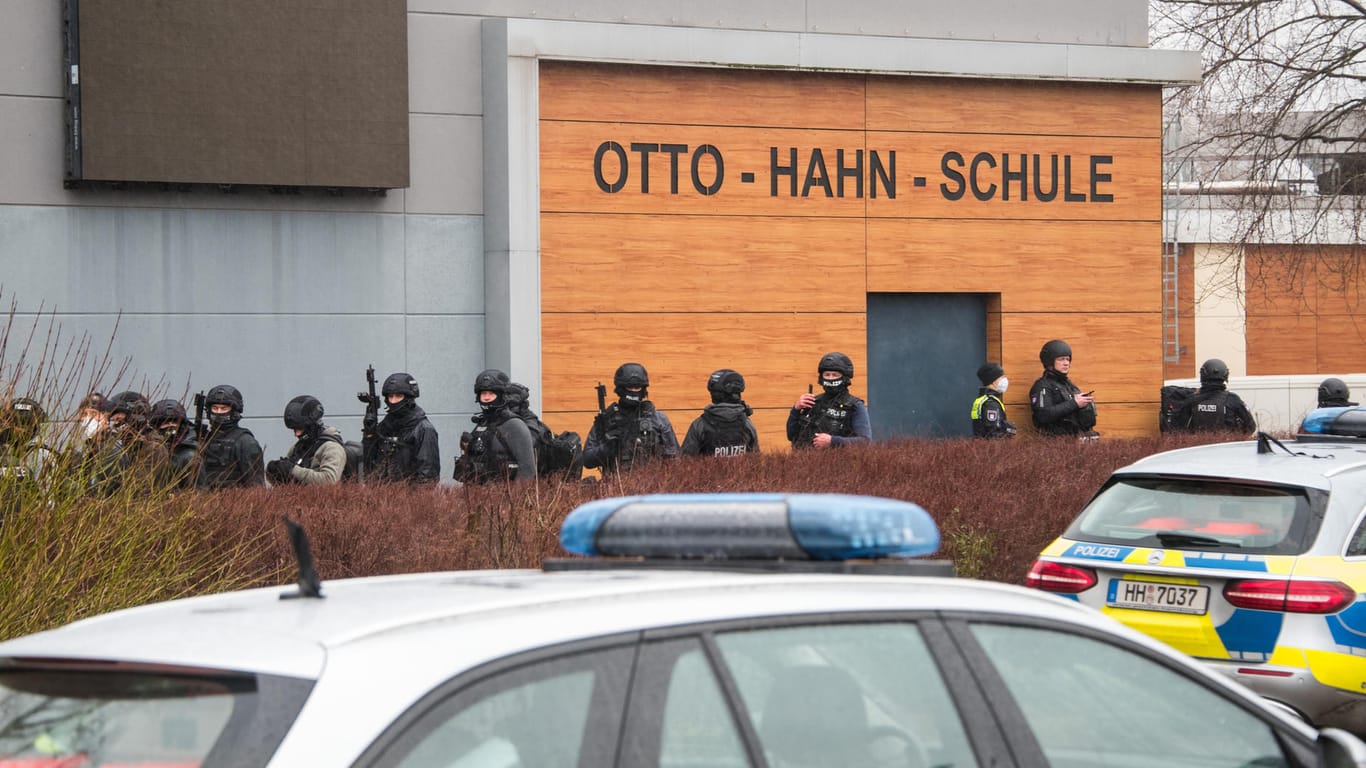 Schwer bewaffnete Polizeikräfte stehen im Stadtteil Jenfeld vor der Otto-Hahn-Schule: Eine Waffe konnte bisher nicht gefunden werden.
