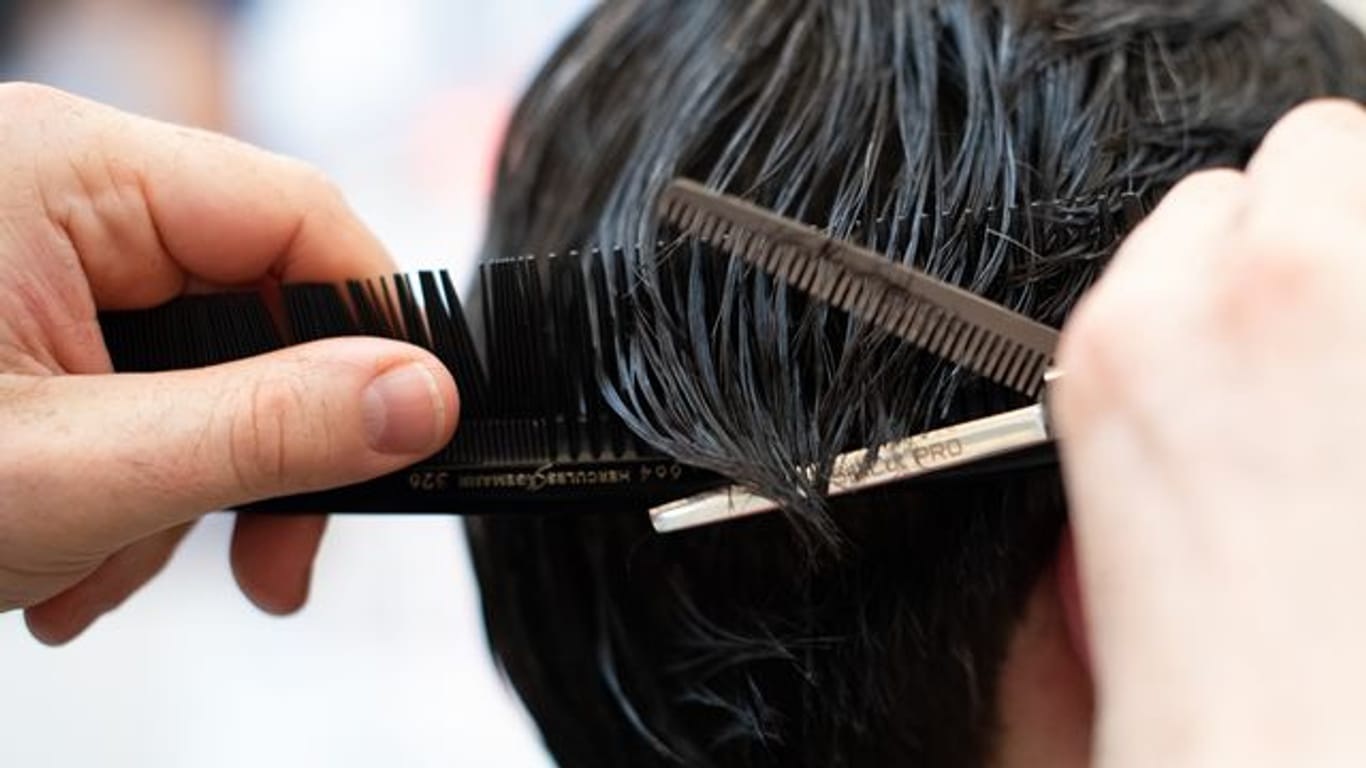 Ein Friseur schneidet einem Kunden die Haare