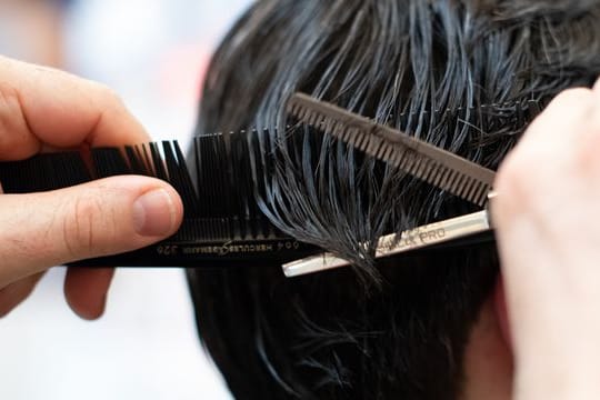 Ein Friseur schneidet einem Kunden die Haare