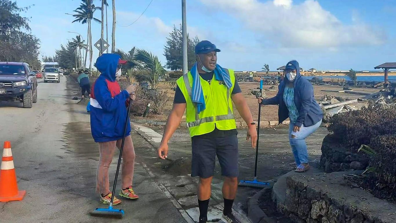 Menschen auf Tonga bei Aufräumarbeiten nach dem Vulkanausbruch: Nach zwei Corona-Fällen hat der Inselstaat einen Lockdown verhängt.