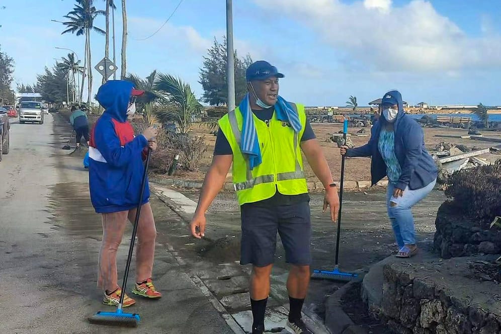Menschen auf Tonga bei Aufräumarbeiten nach dem Vulkanausbruch: Nach zwei Corona-Fällen hat der Inselstaat einen Lockdown verhängt.