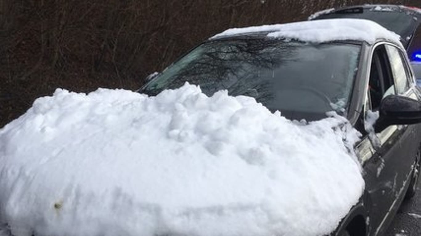 Schnee auf der Motorhaube: Schneestücke flogen während einer Fahrt auf eine Funkstreife.