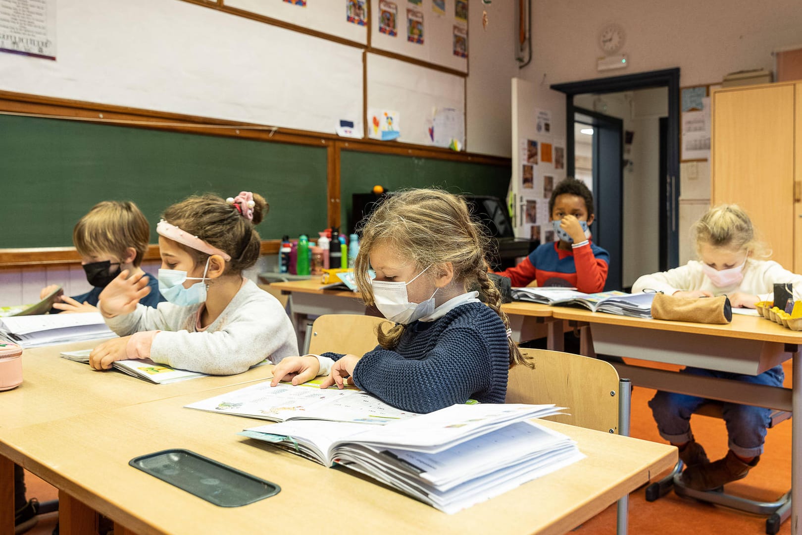Schüler mit Maske im Klassenzimmer (Symbolbild): In Stuttgarter Schulen will man trotz steigender Zahlen am Präsenzunterricht festhalten.