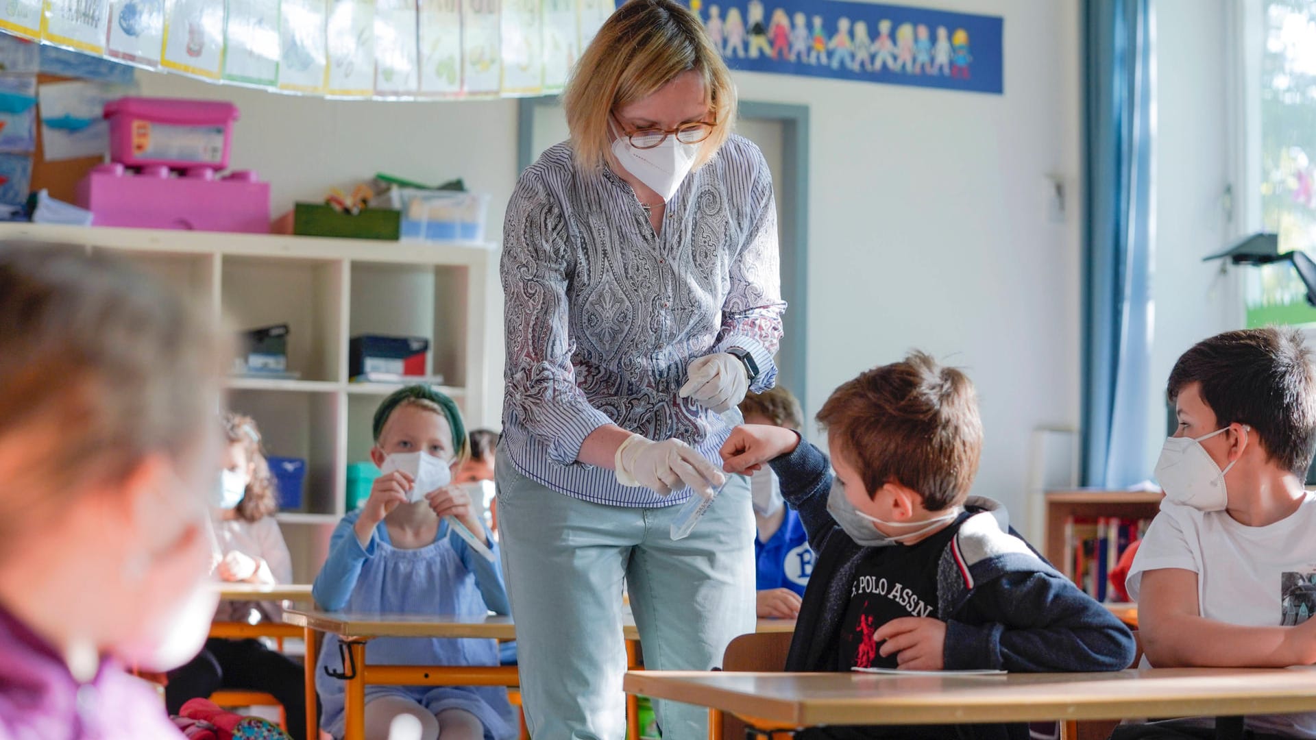 Eine Lehrerin und ihre Klasse beim Durchführen von Lollitests (Symbolbild): Wenn die Kontaktpersonen symptomfrei sind, müssen sie sich nicht mehr in Quarantäne begeben.