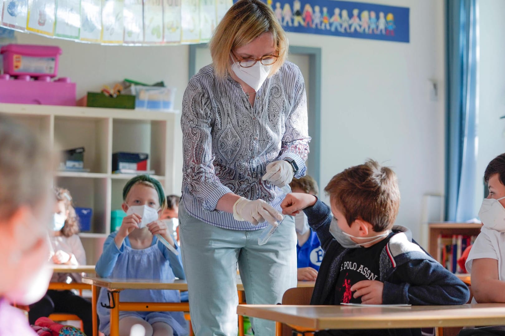 Eine Lehrerin und ihre Klasse beim Durchführen von Lollitests (Symbolbild): Wenn die Kontaktpersonen symptomfrei sind, müssen sie sich nicht mehr in Quarantäne begeben.