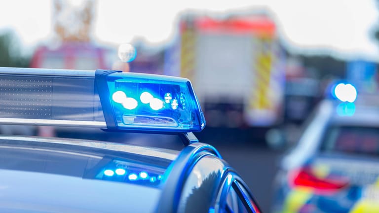 Blaulicht an einem Polizeifahrzeug, Rettungsfahrzeuge im Hintergrund (Symbolbild): Ein Fahrer wurde schwer verletzt, die Fahrerin eines weiteren Wagens musste ambulant behandelt werden.