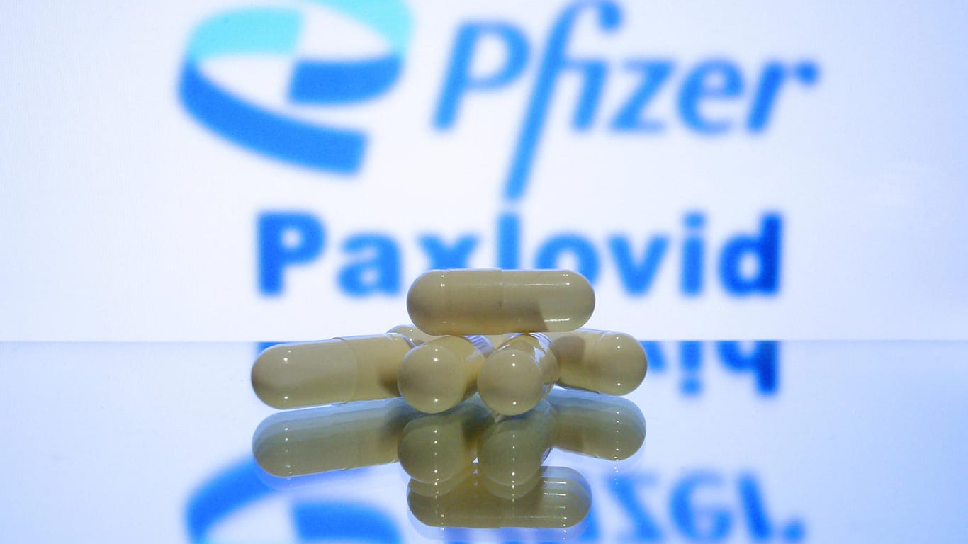 Pillen vor Pfizer-Schild (Symbolbild): Italien möchte mit der Auslieferung des Corona-Medikaments Paxlovid beginnen.