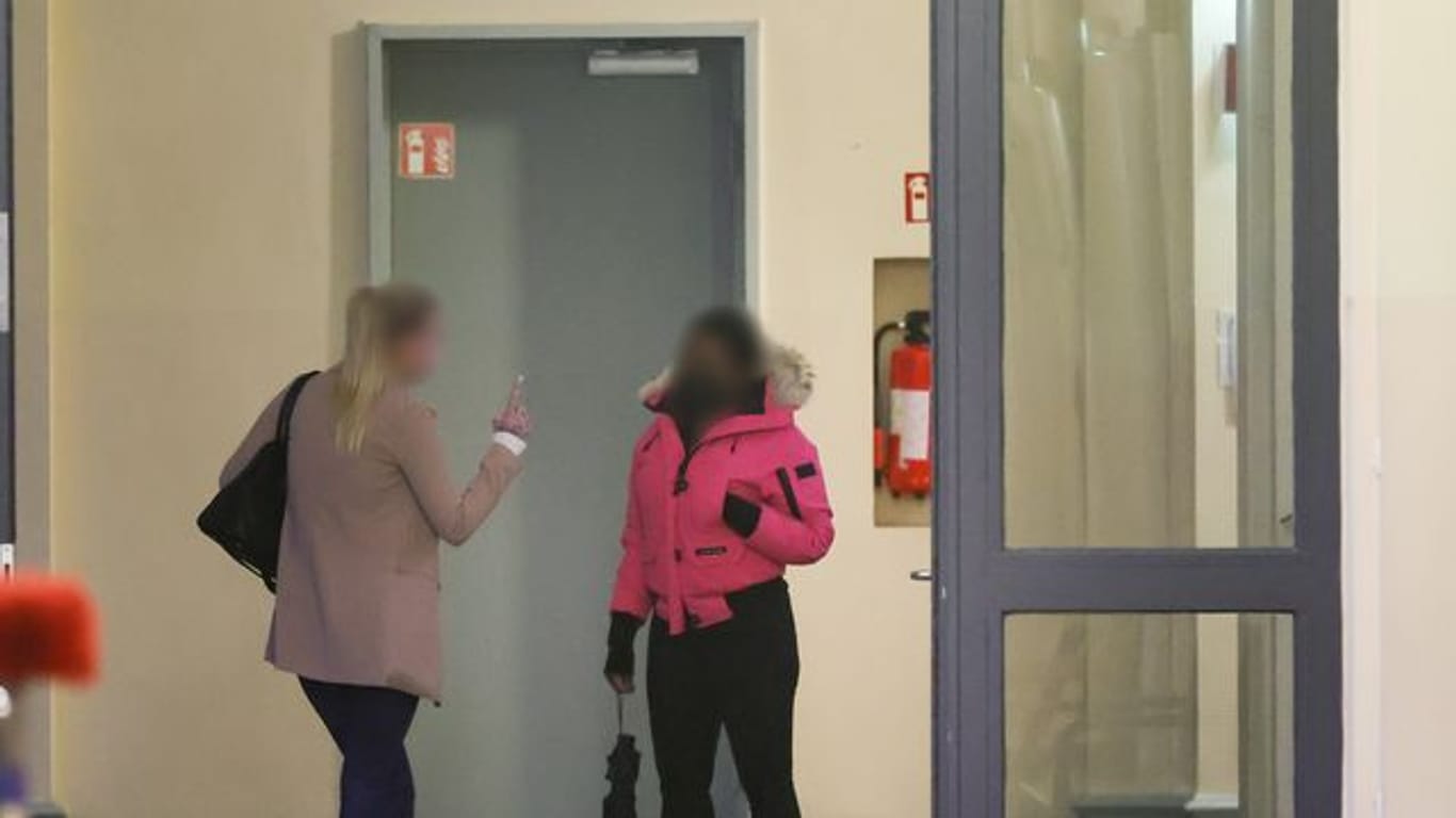 Zwei angeklagte Frauen warten vor einem Gerichtssaal im Strafjustitzgebäude in Hamburg auf den Beginn der Verhandlung.