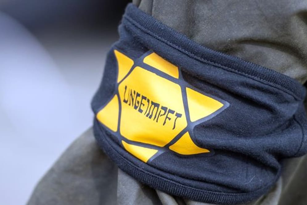 Ein Demonstrant trägt eine Armbinde mit einem Judenstern auf dem "ungeimpft" steht (Symbolbild): In Dortmund hat die Polizei das Tragen des Sterns verboten.