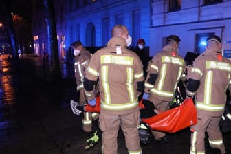 Einsatzkräfte der Berliner Feuerwehr transportieren eine Person ab: Insgesamt wurden fünf Personen ins Krankenhaus gebracht.