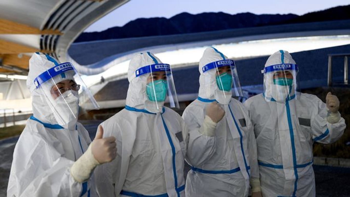 Mitarbeiter eines medizinischen Teams posieren am Olympia-Eiskanal.