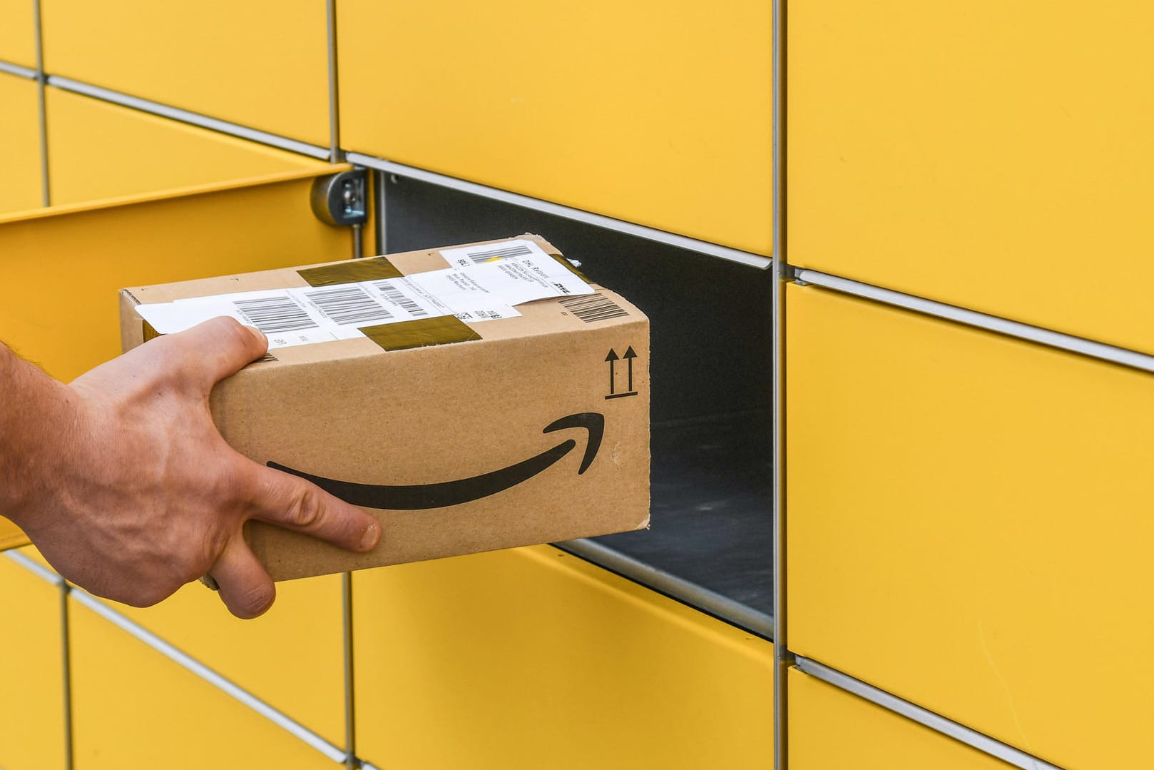 Ein Mann steckt ein Paket ein Amazon-Paket in eine Packstation (Symbolbild): Der Onlinehändler erhöht in den USA seine Preise für seinen Prime-Dienst. Ein Mann steckt ein Paket ein Amazon-Paket in eine Packstation (Symbolbild): Der Onlinehändler erhöht in den USA seine Preise für seinen Prime-Dienst.