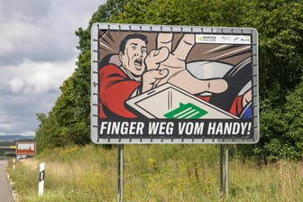 Plakat mit Warnhinweis (Symbolbild): Wer am Steuer Elektronikgeräte wie etwa ein Mobiltelefon in die Hand nimmt, muss mit Bußgeld und Punkten rechnen.