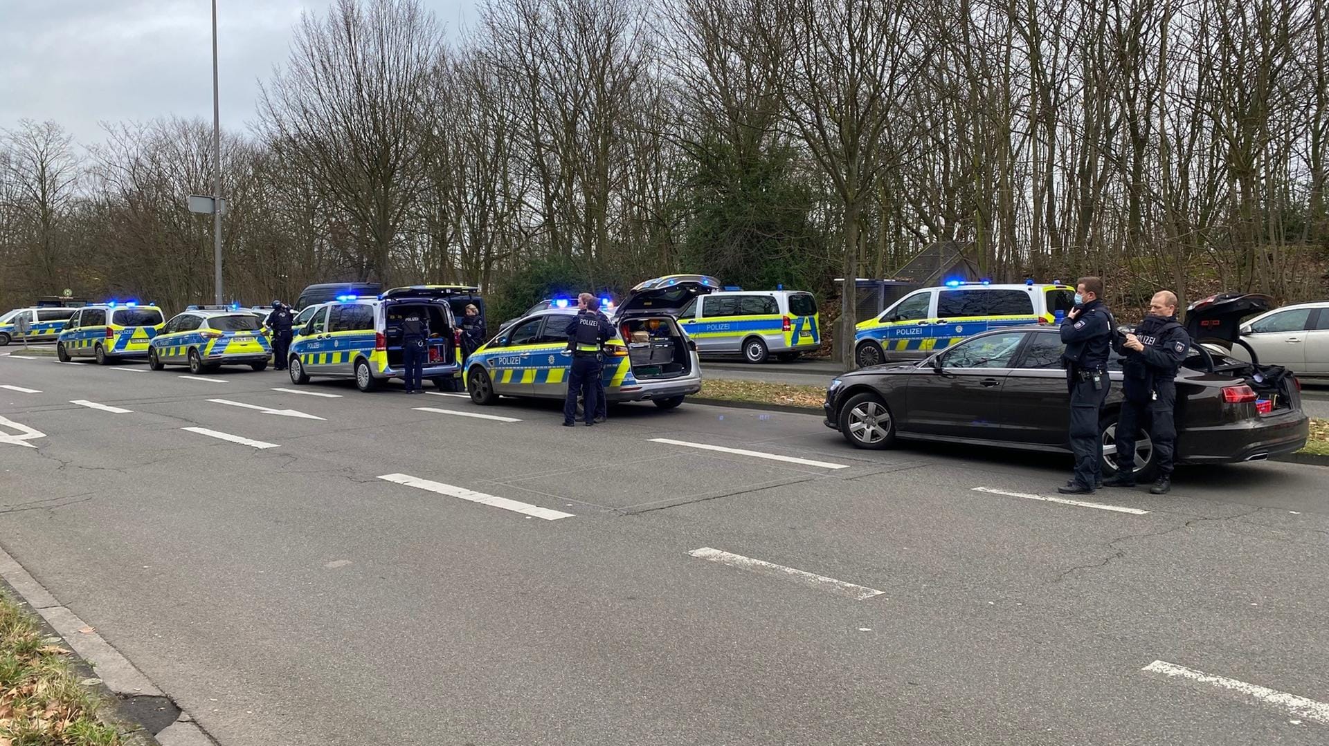 Zahlreiche Polizeibeamte stehen in der Nähe der Schule: Am Morgen hatte ein Schüler einen verdächtigen Mann gemeldet.