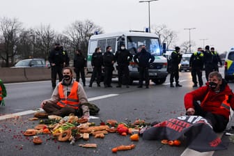 Aktivisten der Kampagne "Essen Retten – Leben Retten" haben sich mit den Händen an einer Berliner Autobahn festgeklebt: Die Berliner Polizei stellen die Blockaden vor Herausforderungen.