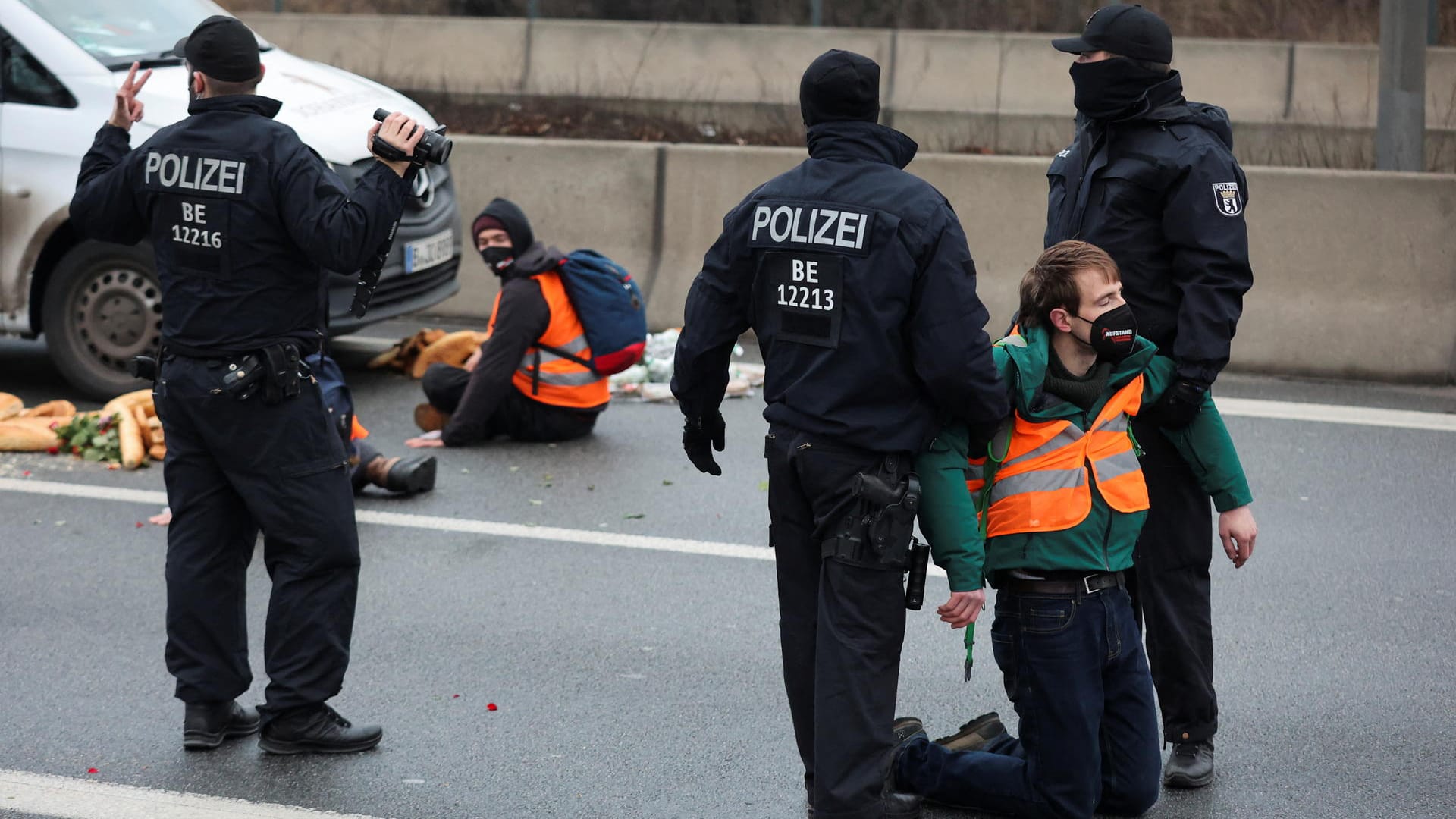 Polizisten tragen einen Straßenblockierer von der Fahrbahn: Um einen Demonstrierenden von der Straße zu entfernen, braucht es laut Polizei mindestens zwei Beamte.