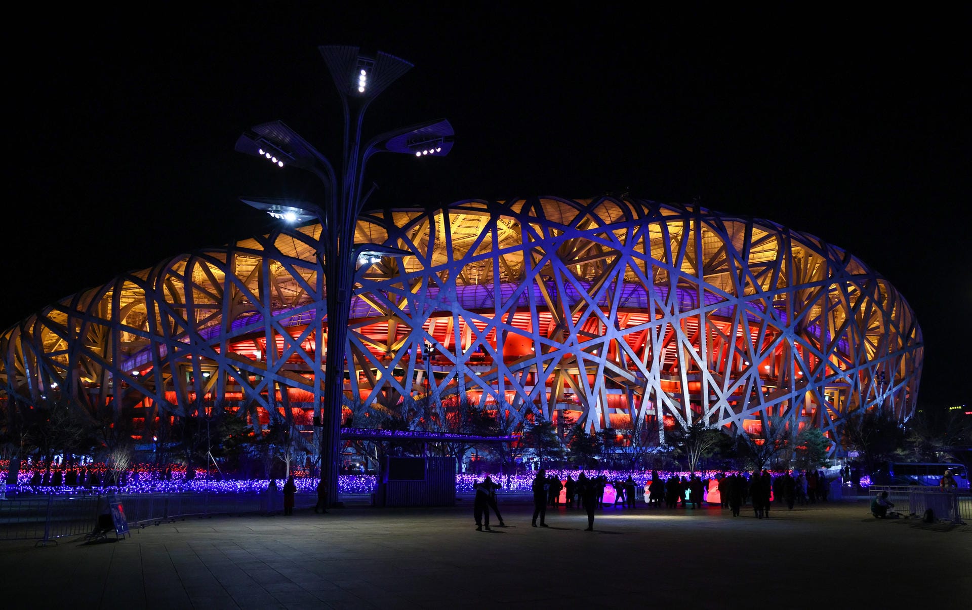 Das Nationalstadion von außen: Es wird auch das "Vogelnest" genannt und erstrahlt in warmen Farben während dieser Eröffnungsfeier.
