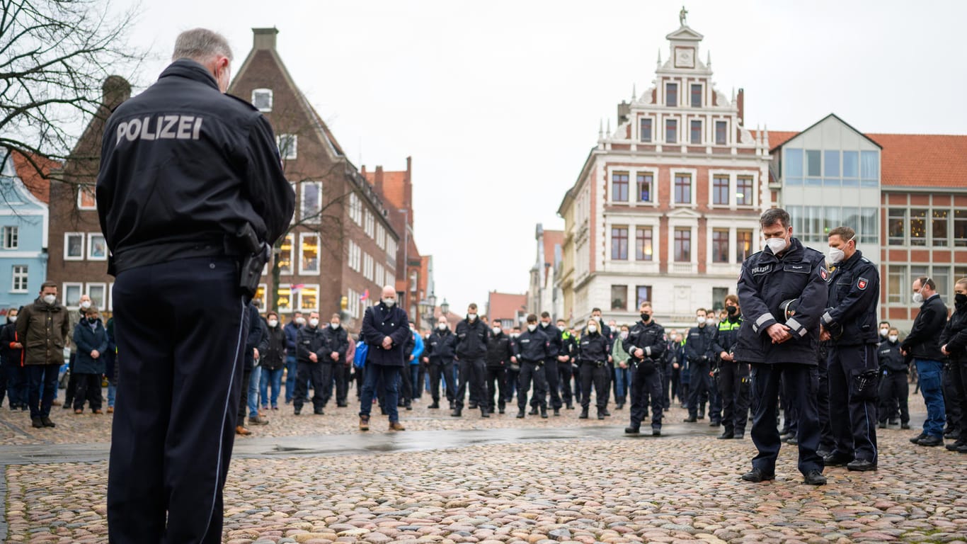 Gedenken in Lüneburg: Polizisten stehen während einer Schweigeminute für die in Rheinland-Pfalz getöteten Polizisten auf dem Marktplatz zusammen.