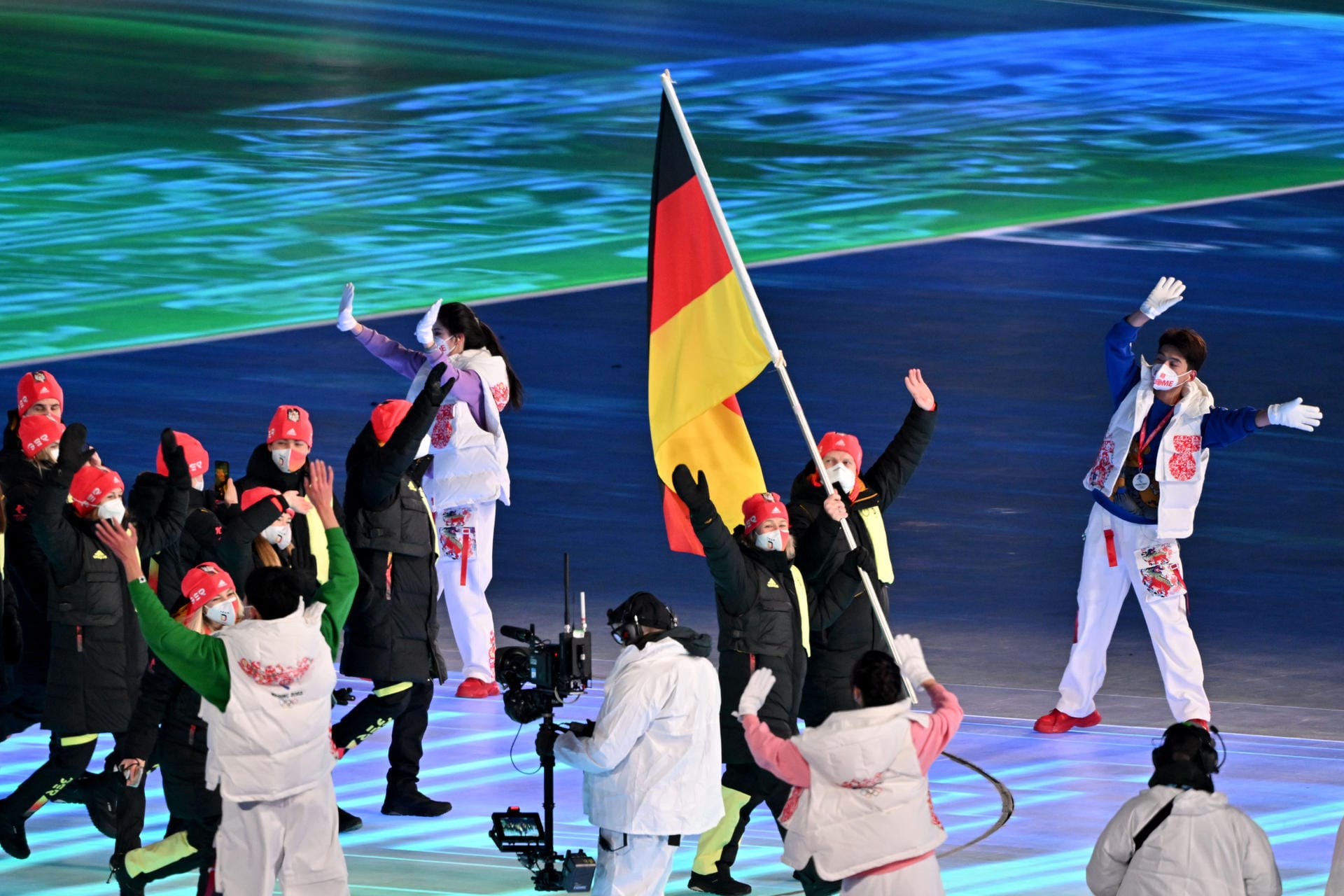 Da sind sie: Claudia Pechstein und Francesco Friedrich führen das deutsche Team ins Stadion und halten die Flagge.