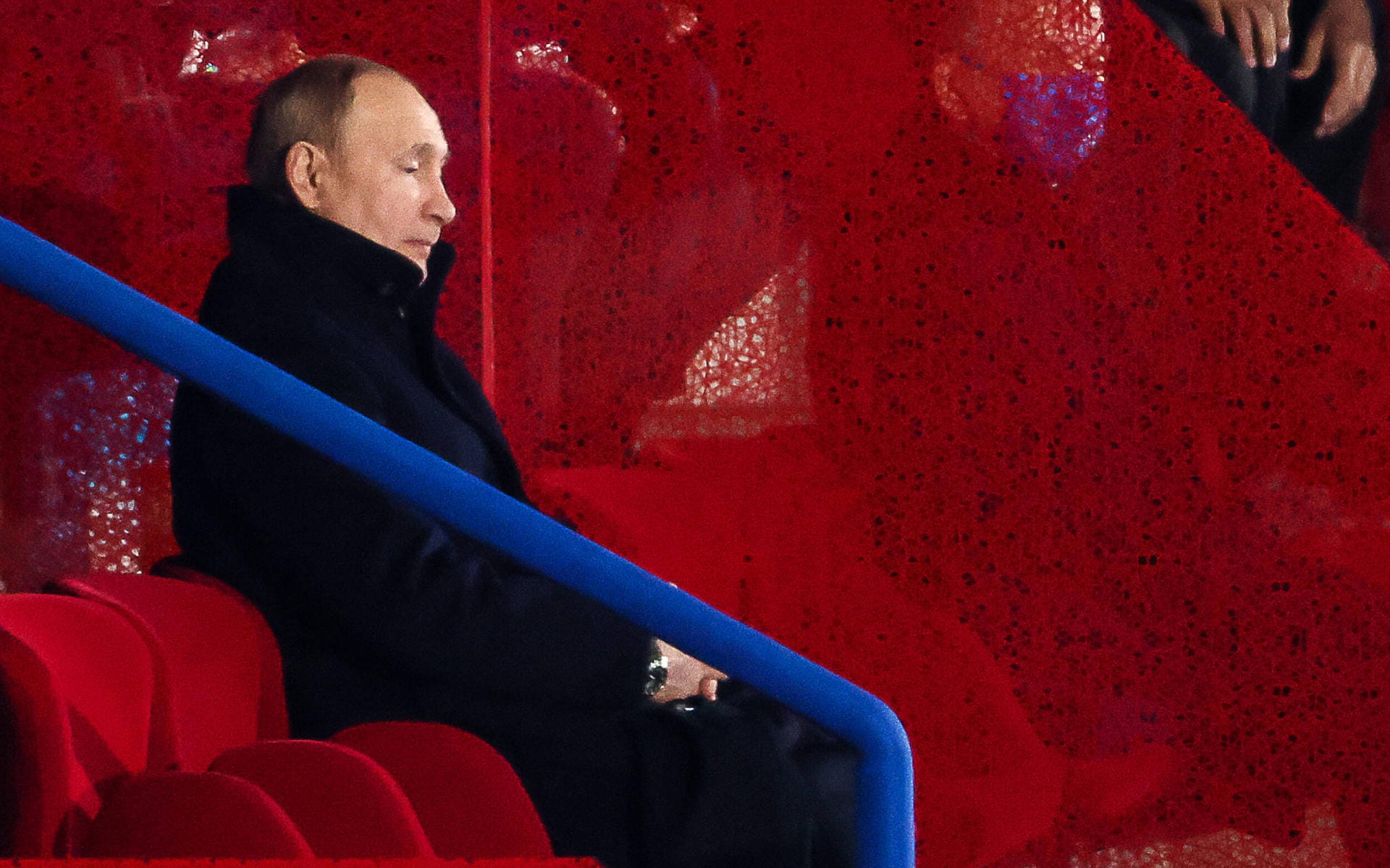 Auch der russische Präsident ist vor Ort: Wladimir Putin sitzt auf der Tribüne und schaut den Sportlern seines Landes beim Einlauf zu.