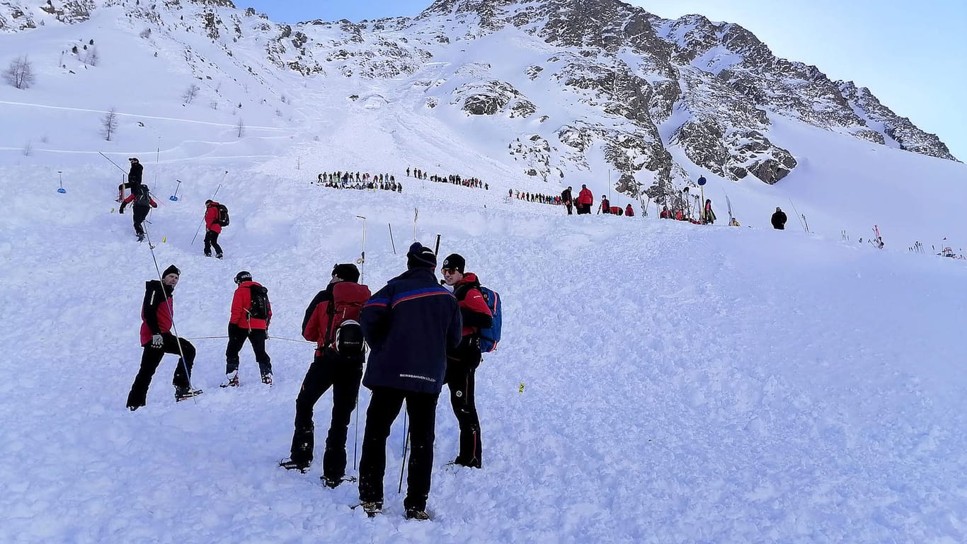 Rettungskräfte sind am Lawinenkegel im österreichischen Sölden im Einsatz: Auch in dem beliebten Skiort verschüttete eine Lawine fünf Wintersportler auf einer gesicherten Piste, doch sie konnten lebend geborgen werden.