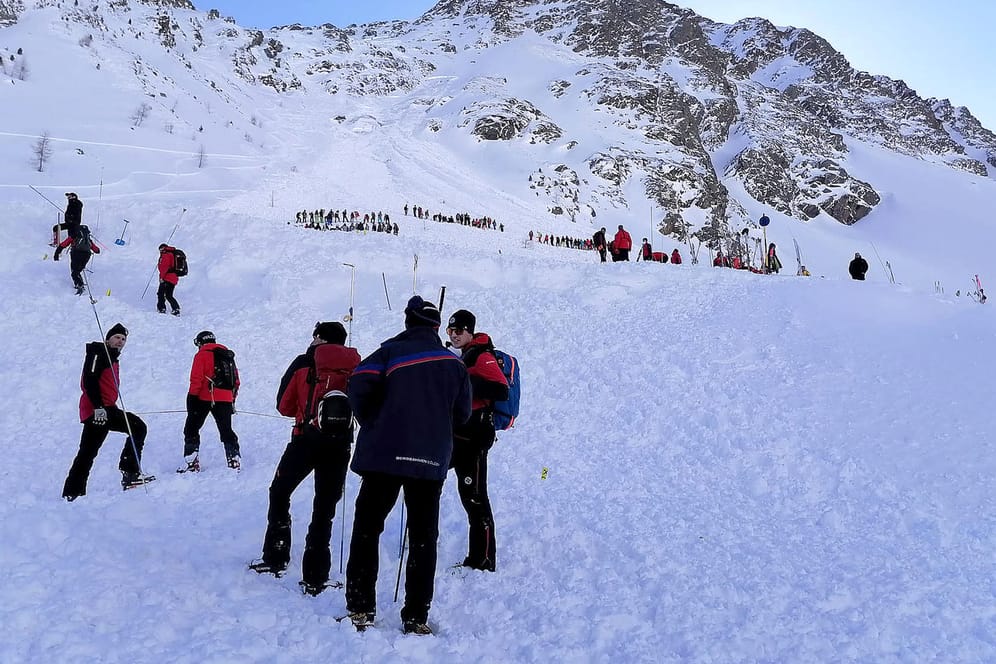 Rettungskräfte sind am Lawinenkegel im österreichischen Sölden im Einsatz: Auch in dem beliebten Skiort verschüttete eine Lawine fünf Wintersportler auf einer gesicherten Piste, doch sie konnten lebend geborgen werden.