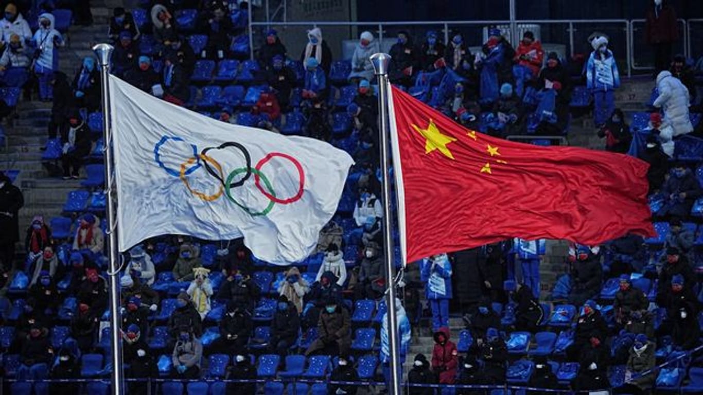 Die Olympische und die chinesische Flagge wehen nebeneinander bei der Eröffnungsfeier der Winterspiele in Peking.