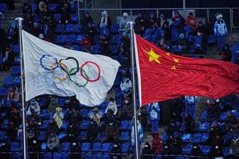 Die Olympische und die chinesische Flagge wehen nebeneinander bei der Eröffnungsfeier der Winterspiele in Peking.