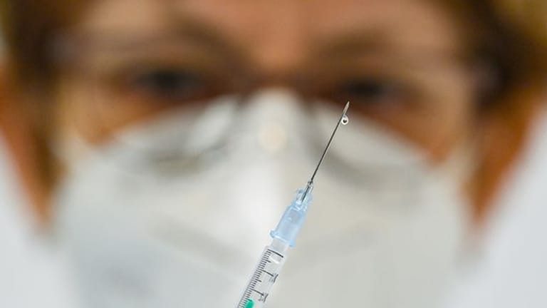 Eine Ärztin hält eine Spritze mit einem Corona-Impfstoff.