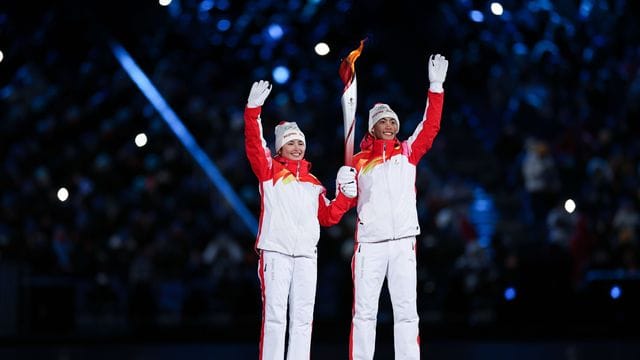 Dinigeer Yilamujiang (l) und Zhao Jiawen mit der Olympischen Fackel bei der Eröffnungsfeier.