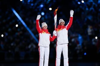 Dinigeer Yilamujiang (l) und Zhao Jiawen mit der Olympischen Fackel bei der Eröffnungsfeier.