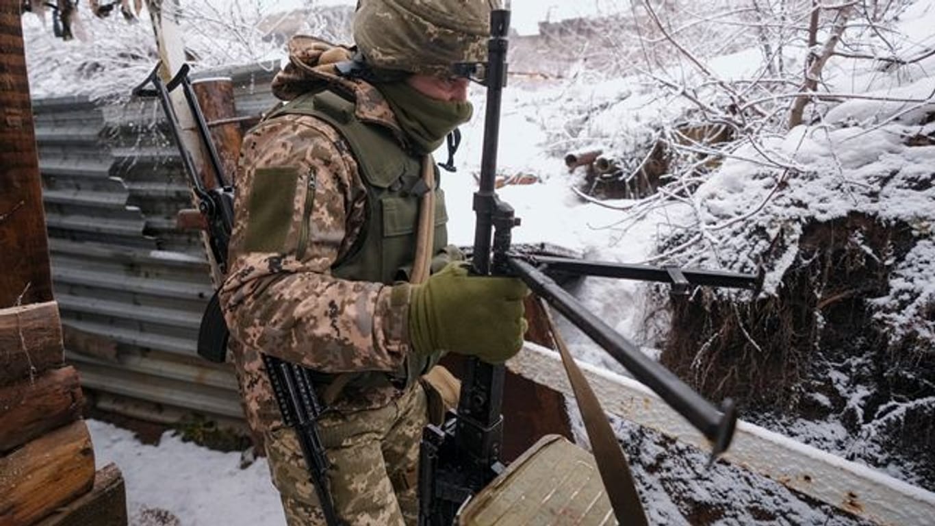 Ein ukrainischer Soldat trΓ€gt in einem Graben an der Frontlinie in der Ostukraine ein schweres Maschinengewehr. Ein ukrainischer Soldat trΓ€gt in einem Graben an der Frontlinie in der Ostukraine ein schweres Maschinengewehr.
