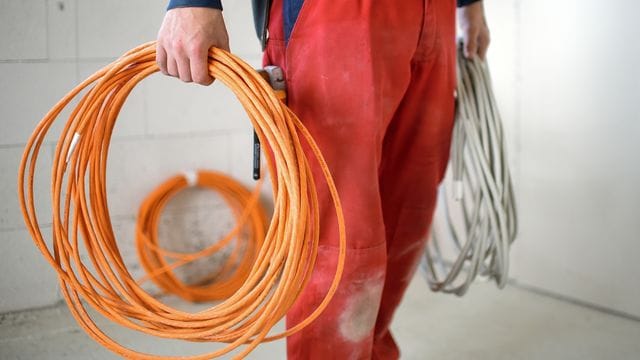 Ein Elektroniker-Lehrling steht auf einer Baustelle