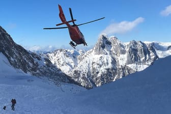 Ein Rettungshubschrauber fliegt über ein Lawinenfeld in den Berchtesgadener Alpen: In den letzten Tagen sind zehn Menschen durch Lawinen ums Leben gekommen.
