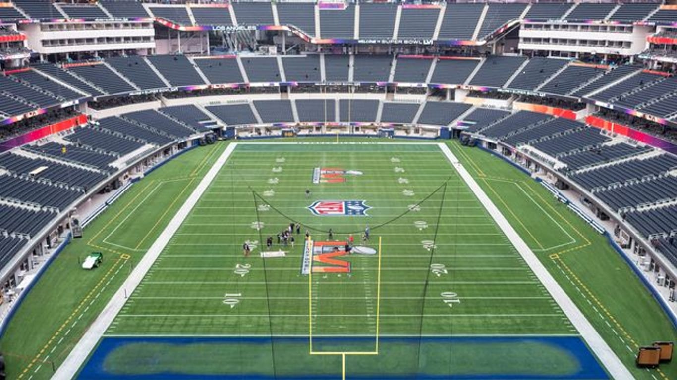Arbeiter malen das Logo des Super Bowl LVI auf das Spielfeld im SoFi Stadion.