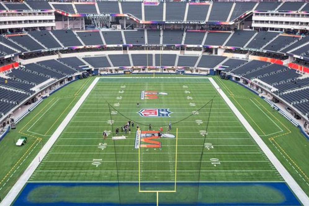 Arbeiter malen das Logo des Super Bowl LVI auf das Spielfeld im SoFi Stadion.