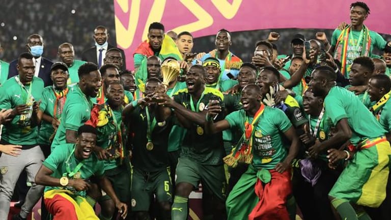 Senegals Spieler feiern mit dem Afrika Cup nach dem Sieg.