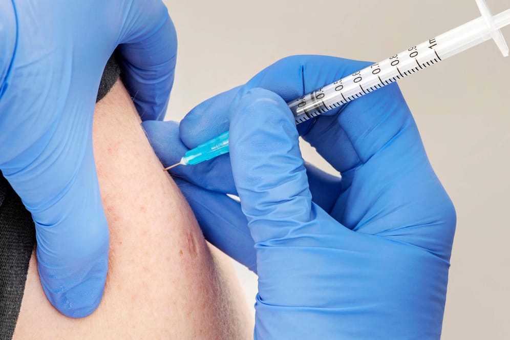 Eine Person wird geimpft (Symbolbild): Die Bundesregierung will die Krankenkassen bei der Impfpflicht einspannen.