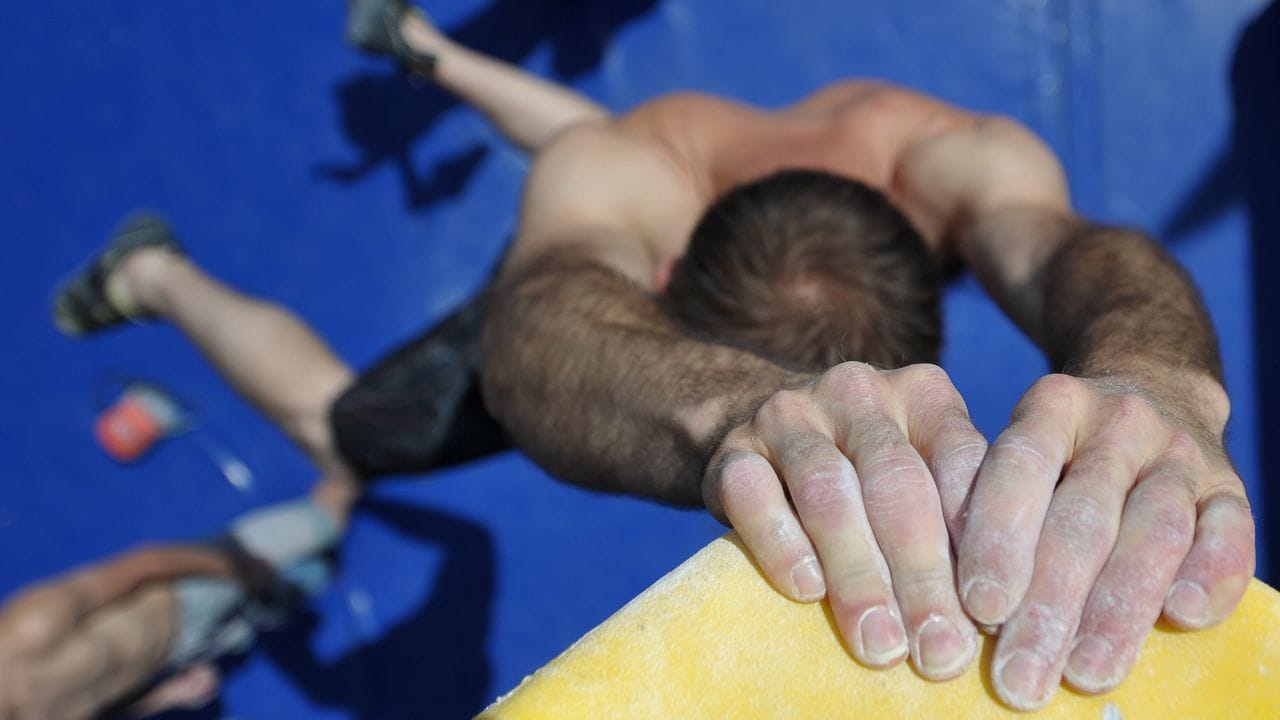 Ohne Absicherung geht es beim Bouldern die Kletterwand hinauf. Ohne Absicherung geht es beim Bouldern die Kletterwand hinauf.