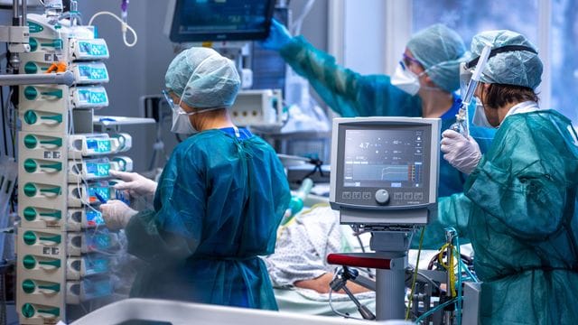 Ärzte und Pflegekräfte betreuen Patienten in einem der Behandlungszimmer der Intensivstation in der Universitätsmedizin Rostock. Ärzte und Pflegekräfte betreuen Patienten in einem der Behandlungszimmer der Intensivstation in der Universitätsmedizin Rostock.