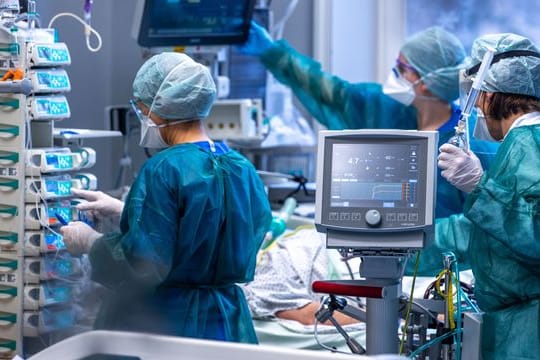 Ärzte und Pflegekräfte betreuen Patienten in einem der Behandlungszimmer der Intensivstation in der Universitätsmedizin Rostock.