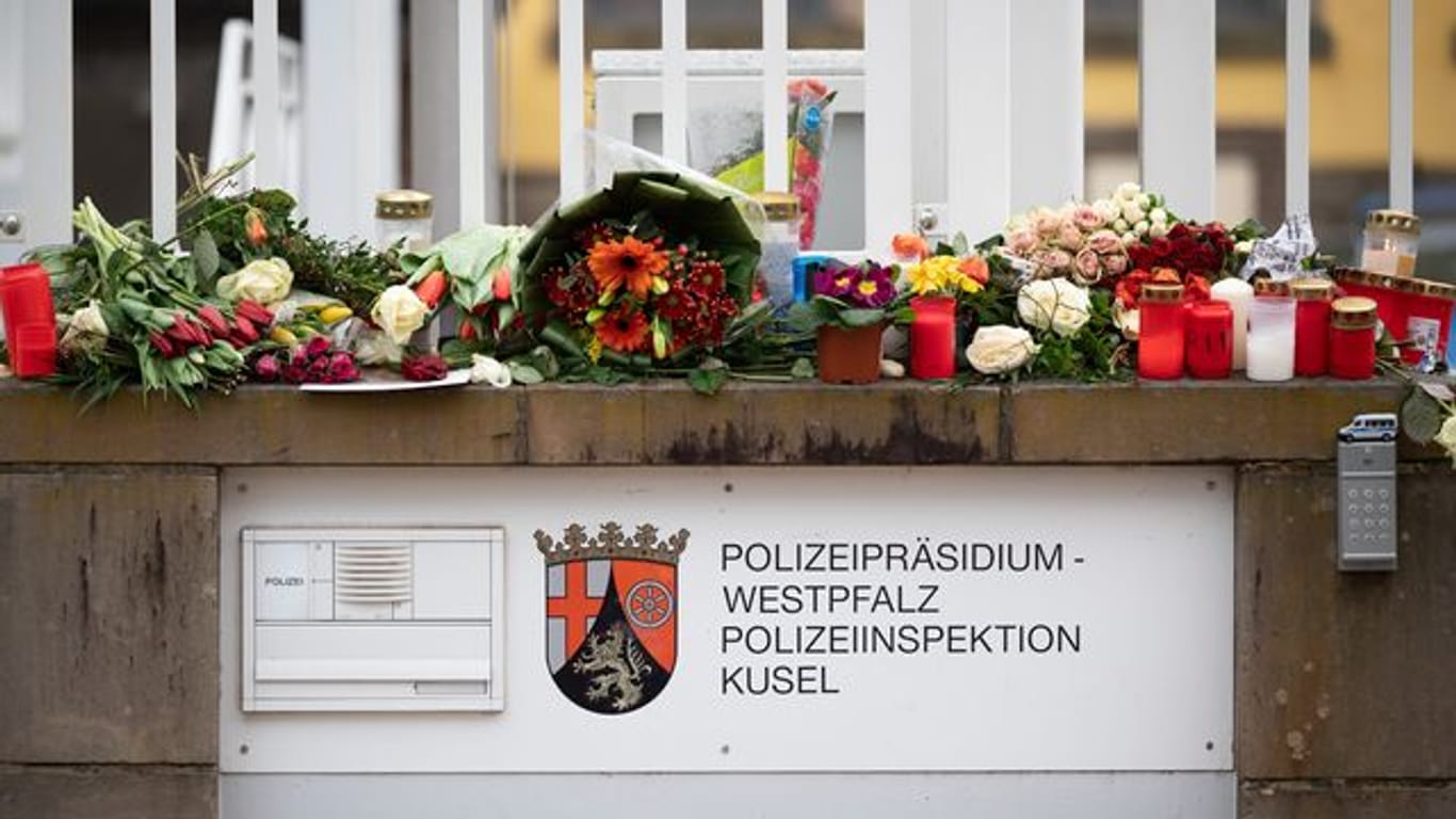 In Gedenken an die ermordeten Beamten: Passanten haben Blumen und Kerzen vor der Polizeiinspektion Kusel gelegt.